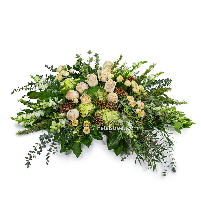 Garden casket spray with soft peach Roses, mini green Hydrangea, Eucalyptus, and mixed foliage.