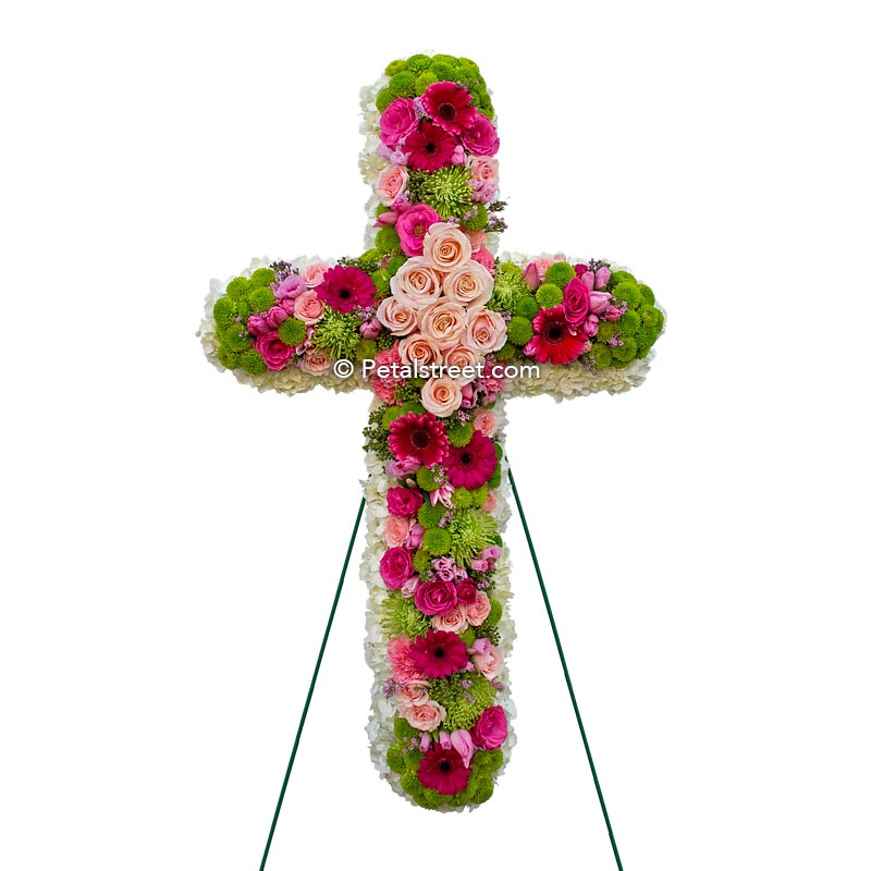 Mixed flower funeral cross with pink, magenta, and green flowers and accents.