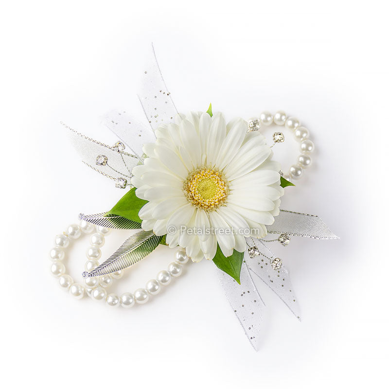 Flower wristlet corsage with white mini Gerbera Daisy with faux rhinestone accents and delicate greenery on a pearl bracelet