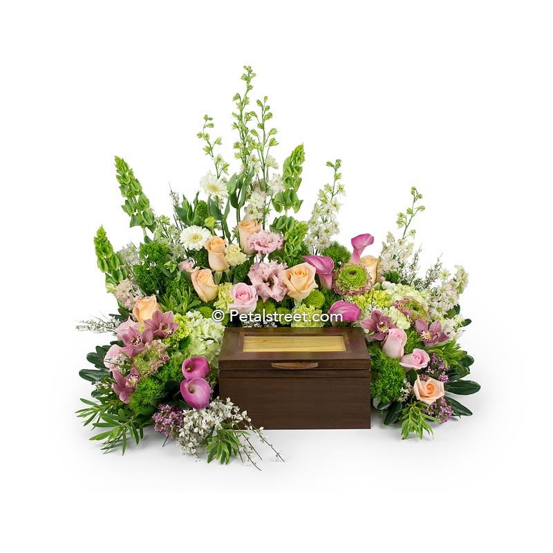 Cremation urn flower arrangement with pink peach Roses, pink Calla Lilies, green mini Hydrangea, and bells of Ireland.