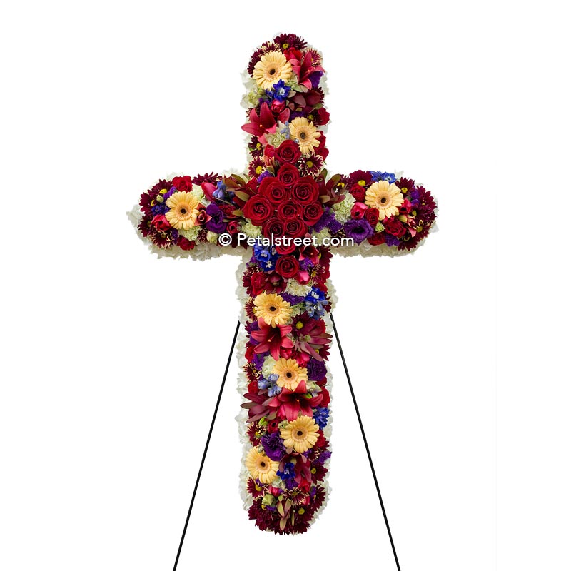 Vibrant funeral cross of flowers with Roses, Daisies, Hydrangea, and Leucadendron.