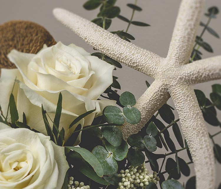 Nautical themed floral arrangement with white roses, eucalyptus and a large starfish accent