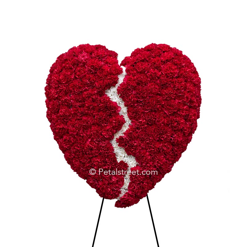 Broken heart form for funeral viewings with red Carnation heart and white Carnation crack down the center.