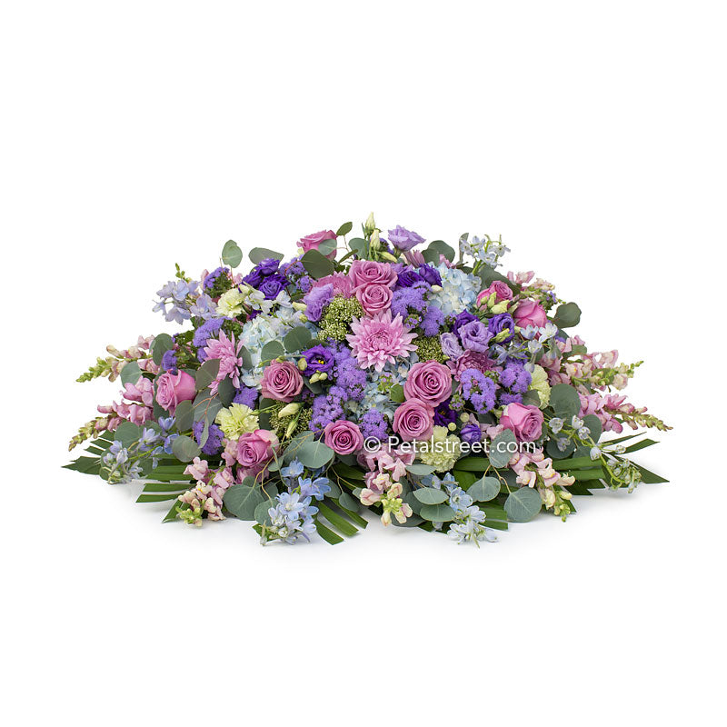 Soft purple, lavender, and blue casket spray with Roses, Hydrangea, and beautiful accent flowers by Petal Street Flower Company.