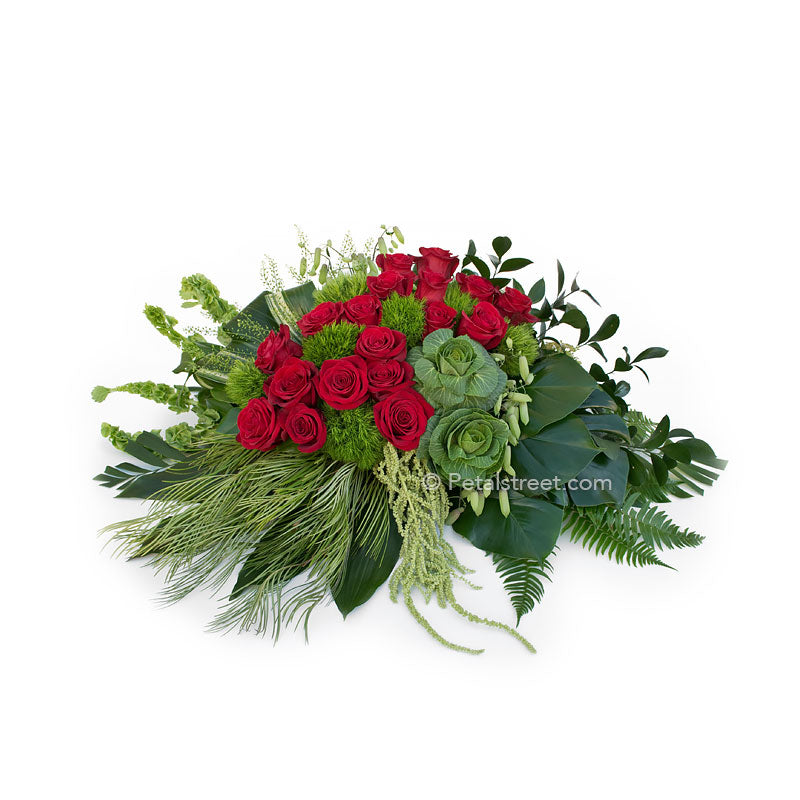 Artisan style casket spray with red Roses, lush Kale, and unique mixed green foliage and textures.