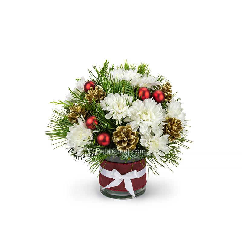 Small Christmas flower vase with white Mums, mixed seasonal greens, gold painted Pine Cones, and red holiday ornament accents.