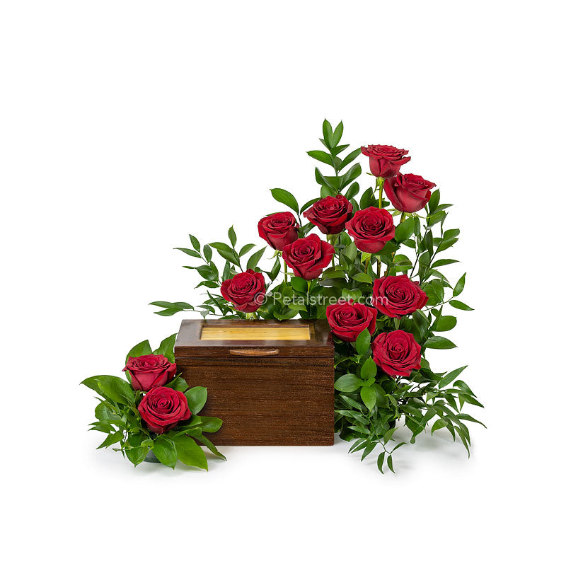 A garden inspired cremation urn flower arrangement with one dozen red Roses and lush accent foliage.