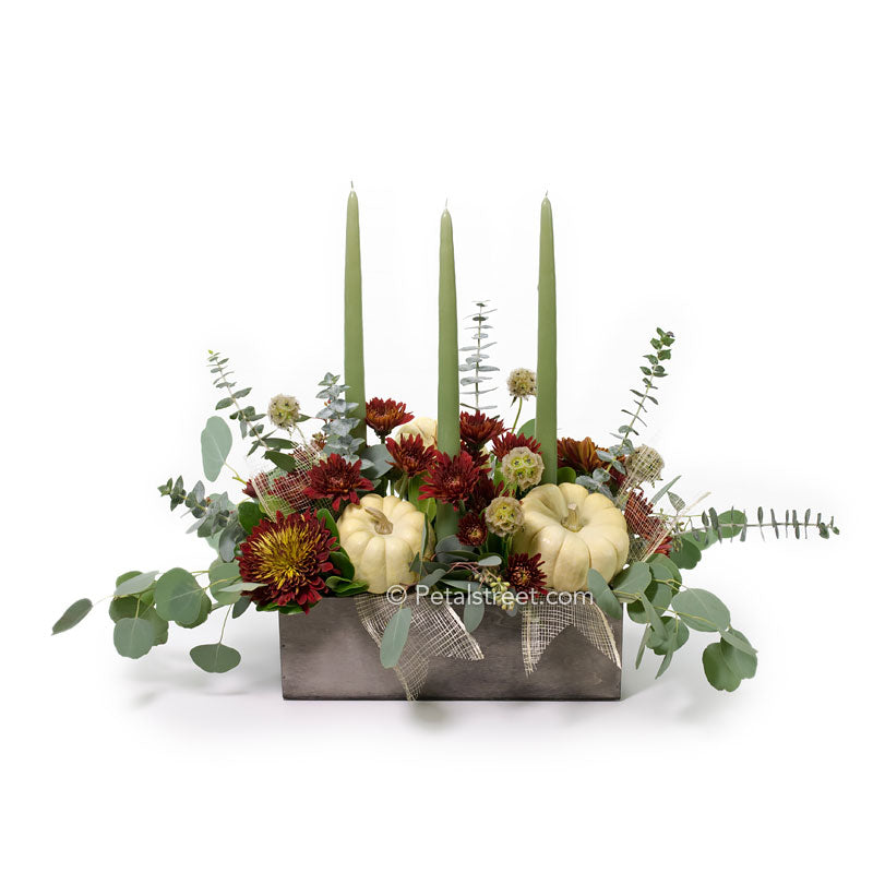 Contemporary Fall Table arrangement in a wood box with Eucalyptus, burgundy Mums, Scabiosa Pods, White mini Pumpkins, and three candles.