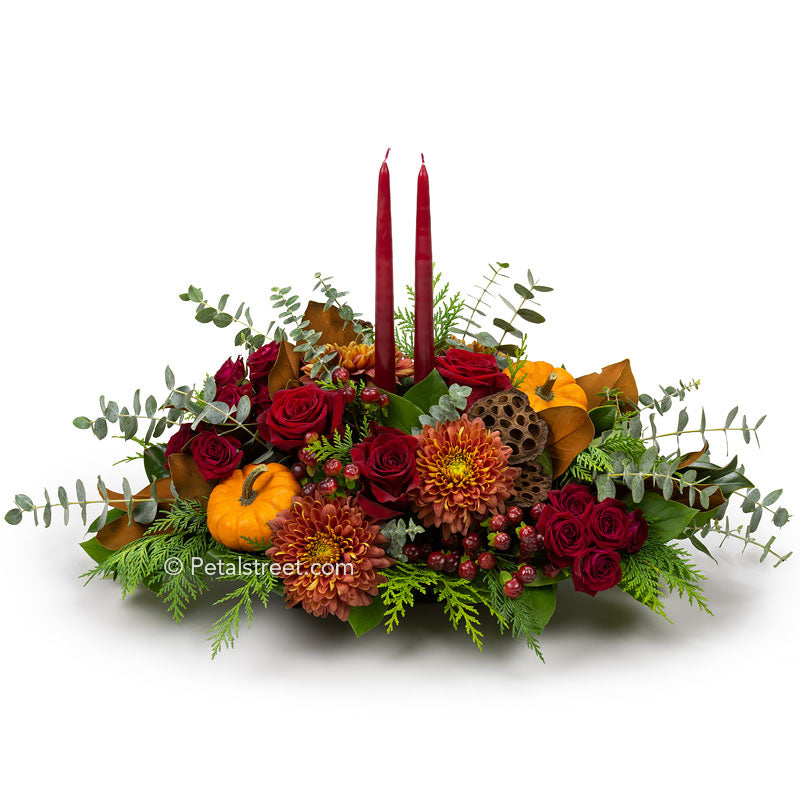 Thanksgiving Centerpiece with red Roses, orange Mums, and red Berries with mini Pumpkin accents and candles.