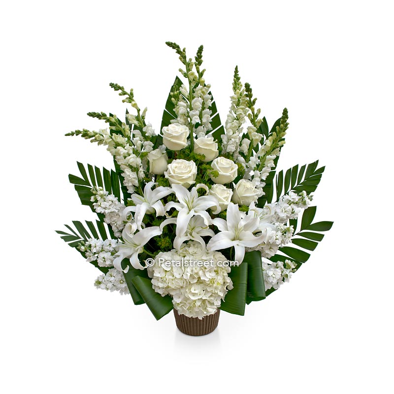 All white flower funeral basket with Lilies, Roses, Snapdragons, and Hydrangea by Petal Street Flower Company florist.