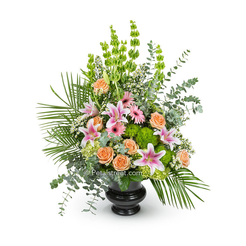 Garden style funeral basket with pink Lilies, peach Roses, green Hydrangea, and a variety of flower and foliage accents.