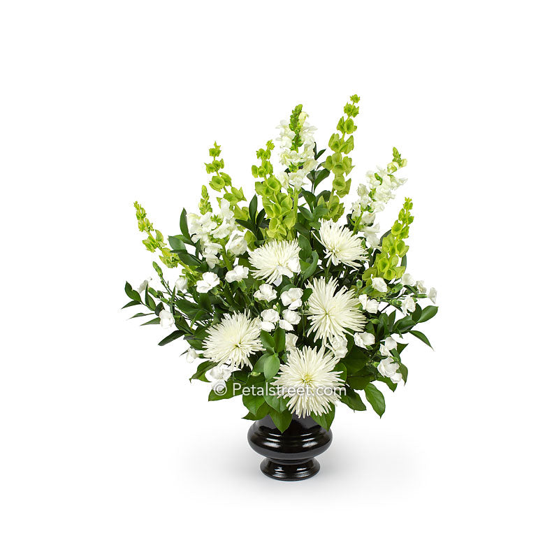Garden style funeral flower basket with large white Mums, mini Carnations, and Snap Dragons, accented with mixed foliage.