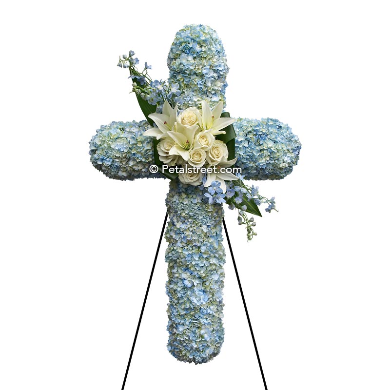 Funeral cross of blue Hydrangea and white Lilies and Roses, a gorgeous piece.