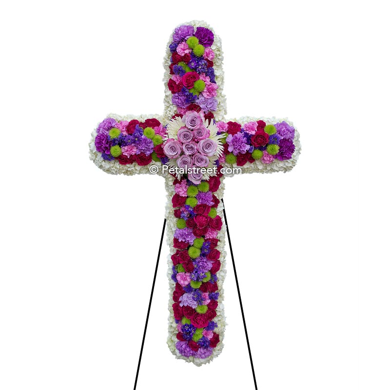 Mixed flower funeral cross with white, purple, and magenta mixed flowers.