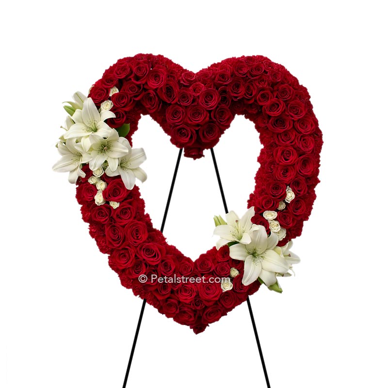 Red Rose funeral heart form with red Carnation outline and gorgeous white Lilies accenting the upper left and lower right of this piece.