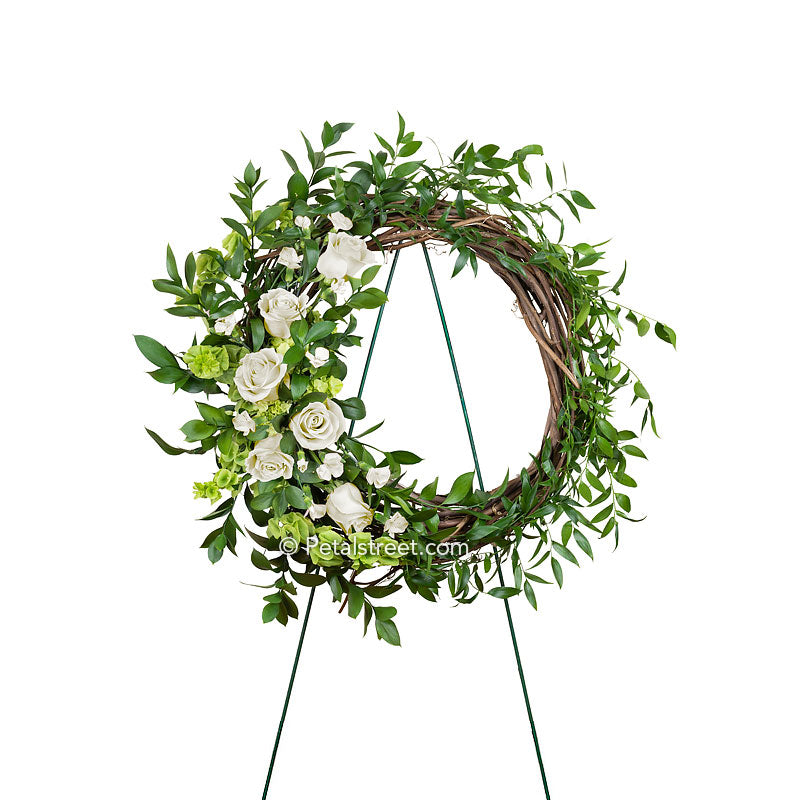 Funeral wreath made on a dried grapevine ring with white Roses, white accent flowers and mixed foliage made by Petal Street Flower Company florist in point pleasant, NJ.
