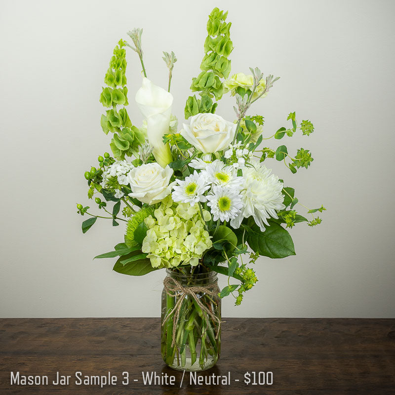 Large white and green mason jar flower arrangement with Roses, mums, and sweet William, Hydrangea, bells of Ireland, and accent greens