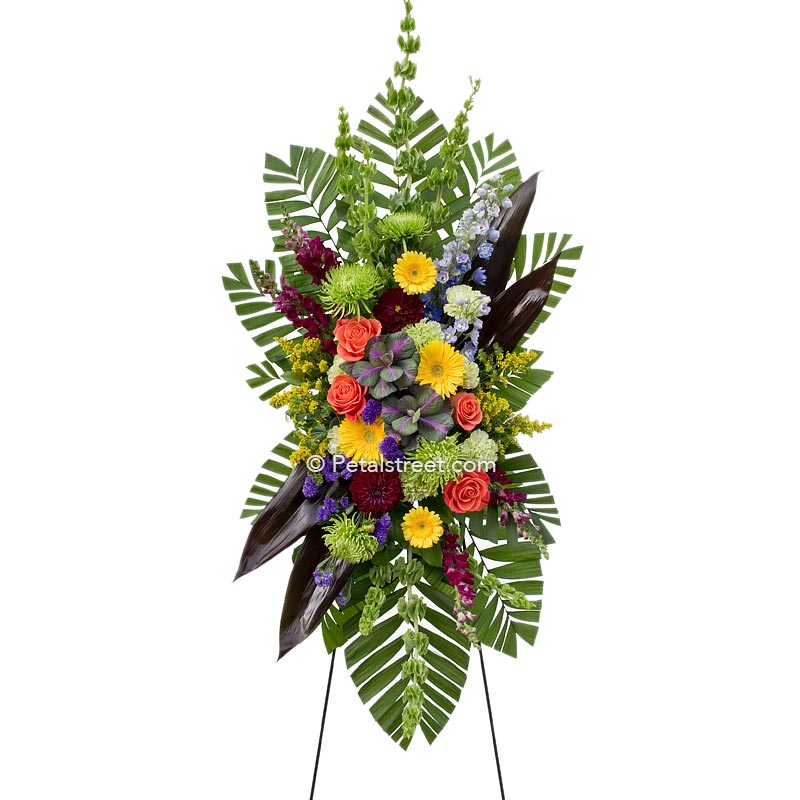 This standing spray has yellow Daisies and orange Roses accented with a colorful assortment of complimentary flowers.