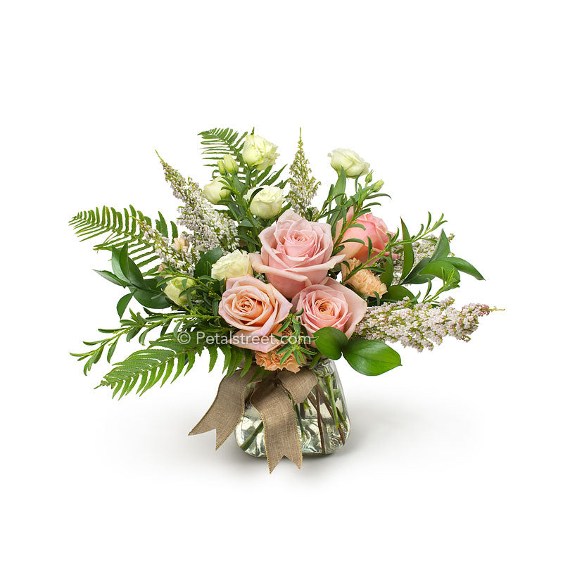 I mixed bouquet of Roses, Lisianthks, and other assorted flowers hand gathered and arranged in a vase.