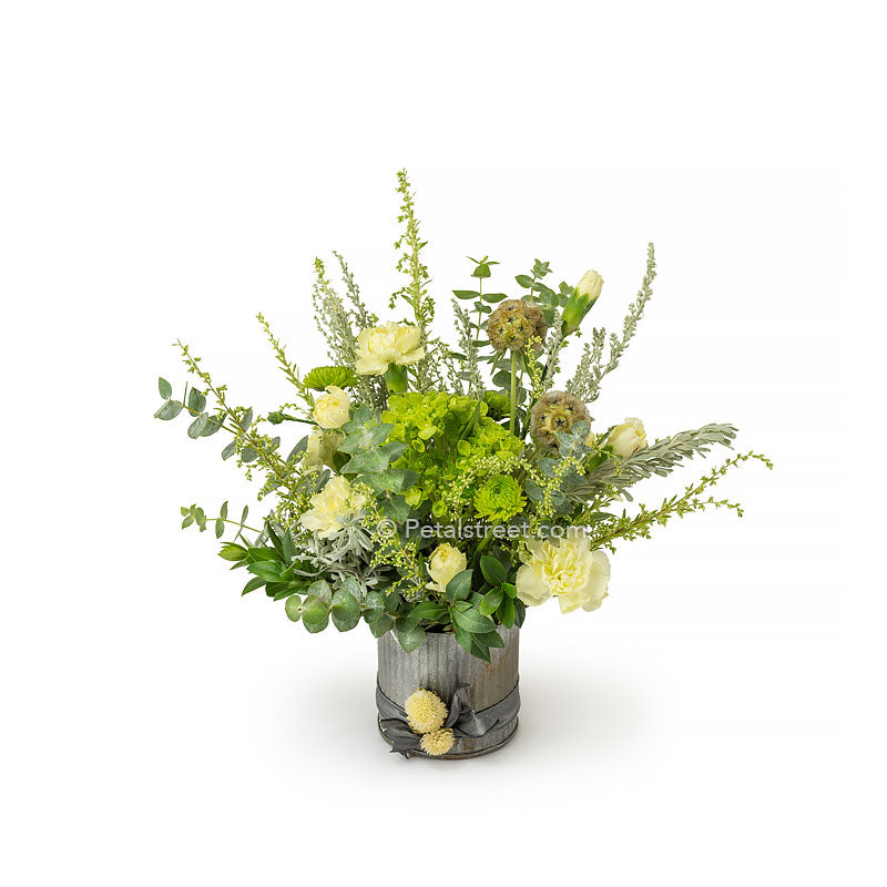 Small rustic Autumn floral arrangement in a tin cylinder with small bloom Hydrangea, Eucalyptus, Solidago, and dried Scabiosa Pods.