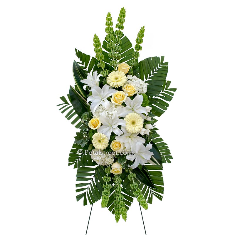 Soft yellow and white funeral standing spray with Lilies and Gerbera Daisies.